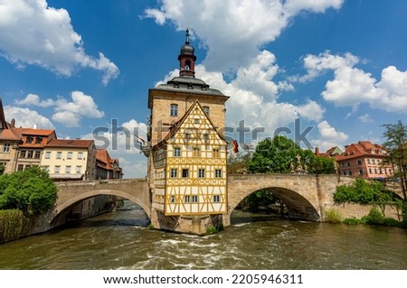The historic town hall of Bamberg on an island in the middle of the river Regnitz with two bridges connecting it with the shore in summer weather