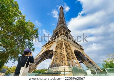 Holidays in Paris. Eiffel Tower seen by female tourist taking picture - focus on the tower 