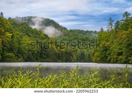 Start of Fall at Mill Creek Lake, with fog over the lake, cliffs in background
