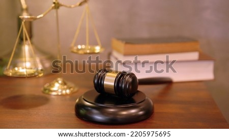 Lawyer or judge's hammer in the court. Auction's hammer is on woo table. Law subject or auction firm with book and golden judge's scale as symbol. Royalty-Free Stock Photo #2205975695
