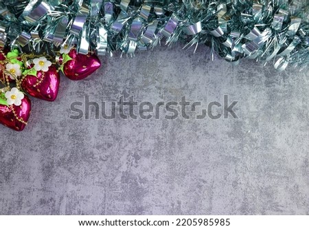 Blue tinsel and Christmas tree toys hearts on a gray background