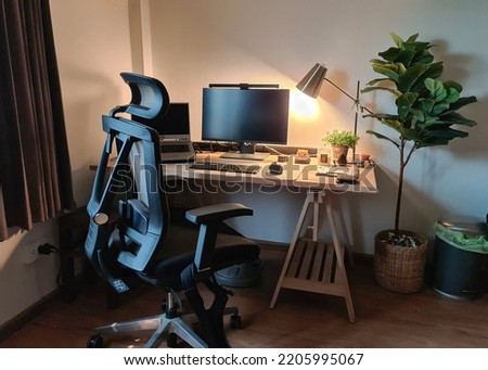 Working corner with monitor, laptop, wooden desk, ergonomic chair and decorate object in bedroom Royalty-Free Stock Photo #2205995067