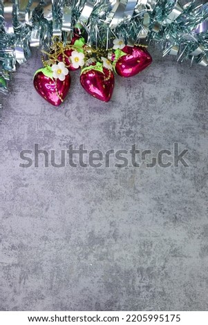 Blue tinsel and Christmas tree toys hearts on a gray background