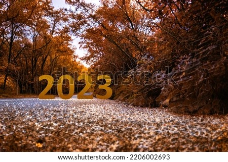 Happy New Year 2023 anniversary is coming. Transition from 2022 to new year concept with 2023 text on road. Photo image can be used as large display, print, website banner, social media post.