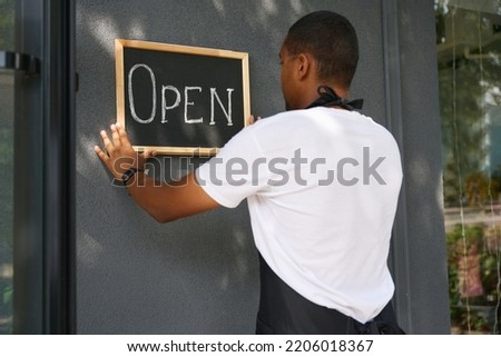 African american man hanging a sign on the wall