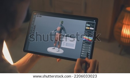 Male 3D designer creating design of clothes in 3D modeling application using tablet computer and digital pencil while working remotely on freelance project