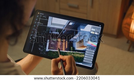 Male 3D designer having remote freelance project and working on smart house exterior in 3D modeling application using digital tablet computer and pencil Royalty-Free Stock Photo #2206033041