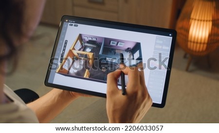 Male 3D designer using digital tablet computer and pencil and creating interior of house in professional design application while working on project remotely Royalty-Free Stock Photo #2206033057
