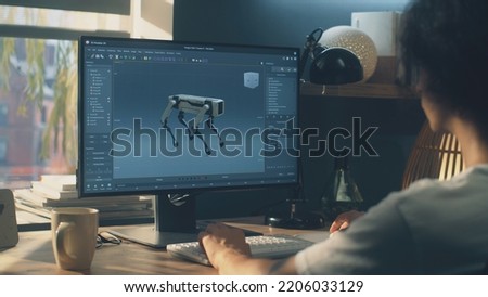 Man sitting at the table and creating 3D prototype of modern robot while working on pc in 3D modeling program remotely from home office