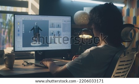 Male young 3D designer having remote work on 3D modeling and designing clothes using pc with professional software while sitting at the table at home Royalty-Free Stock Photo #2206033171