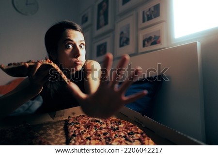Woman Hiding Her Unhealthy Habit of Eating Pizza at Night Royalty-Free Stock Photo #2206042217