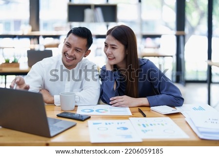 startup business, portrait of two entrepreneurs using computers and financial budget documents to make marketing plans to increase profits.