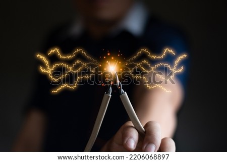 A engineer hand catch electricity wire blur background, computer graphic light, renewable power and energy , save energy concept yellow style copy space for text
