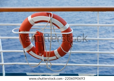 Lifebuoy or life ring orange on the ship with backdrop of the sea landscape. Safety equipment. High quality stock photo image of obligatory ship equipment, personal flotation device prevent drowning