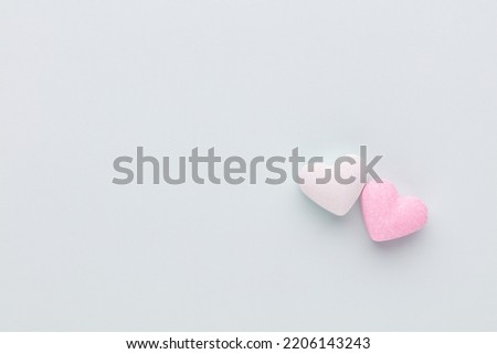 Valentine's Day background. Composition with candy hearts on pastel blue background. Valentines Day greating card. Flat lay, top view.