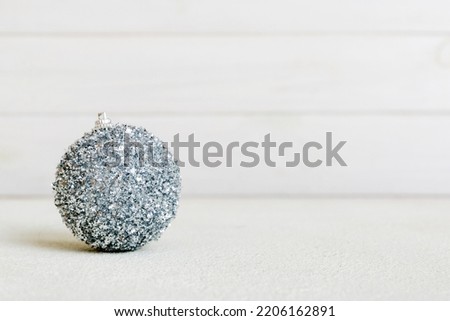 Christmas ball on colored background. decoration bauble with ribbon bow with copy space.