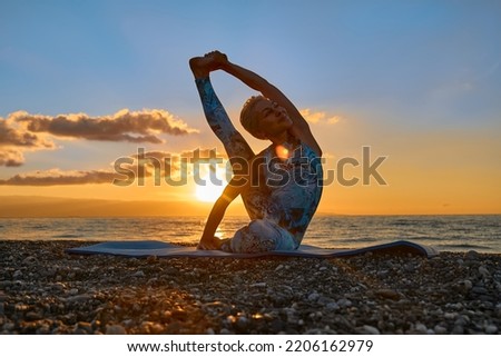 Young woman practicing yoga on the beach at sunrise. Harmony, wellbeing, meditation, healthy lifestyle, relaxation, yoga, self care, mindful meditation concept.