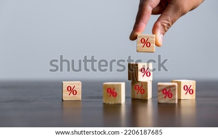 Closeup wood cubes with percentage symbol, Interest rate and dividend concept, wooden block with percentage symbol and up arrow, return on stocks and mutual funds, long term investment for retirement.