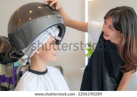 European woman hairdresser in beauty salon cut hair and hair design to her customer Royalty-Free Stock Photo #2206190289