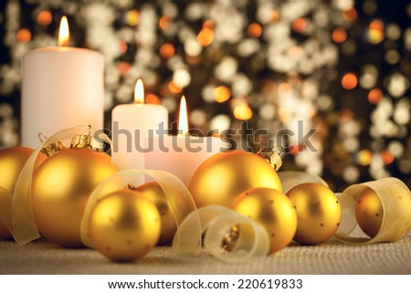 Warm Christmas glitter bokeh background with candles, baubles and ribbons