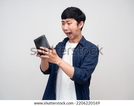 Young asian man looking in his wallet but no money feels shocked Royalty-Free Stock Photo #2206220169
