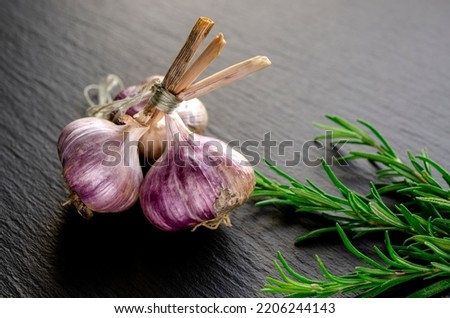 Spices for cooking. Garlic and rosemary lie on a black background