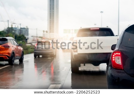 Abstract of rear side of black car. Rear side view of car in rainy time and traffic jam. Traffic congestion with many queues due to the wet asphalt road surface. 