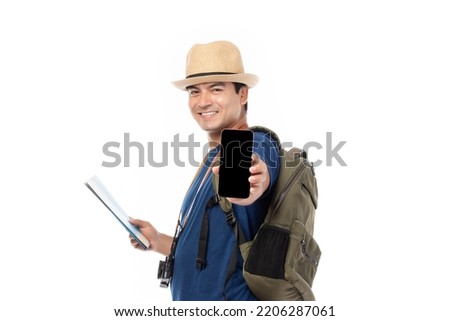Portrait of cheerful young traveler man with backpack isolated on white background. Tourist man looking happy holding mobile phone and map.