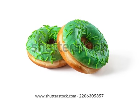 Donuts covered with green icing and sprinkled with green sprinkles isolated on a white background