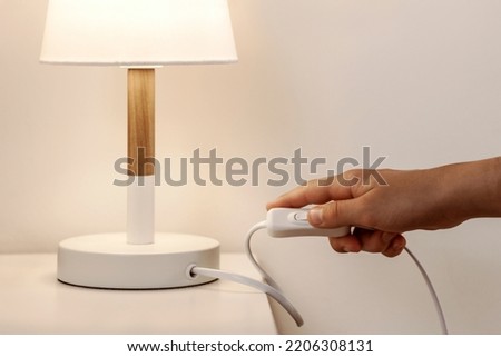 Turn off Lamp indoor, Saving Energy concept. Switch off Table Lamp Local Light in Bedroom. Royalty-Free Stock Photo #2206308131