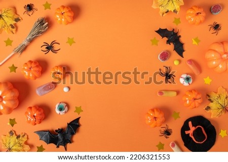 Halloween background with pumpkins and spiders and sweets on an orange background with a place for text.