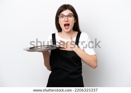 Young Russian woman chef with tray isolated on white background surprised and shocked while looking right Royalty-Free Stock Photo #2206325337