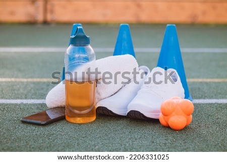 Sports equipment for sufficient quality training and fun. Sports outdoor playground. Game lifestyle. Equipment for runners - shoes, drink, reaction ball, mobile. Royalty-Free Stock Photo #2206331025