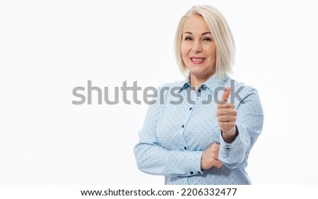 Cheerful smiling blonde business woman lady in blue shirt standing showing Ok gesture looking camera isolated on white background selective focus.