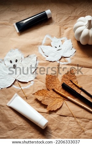 Halloween ghosts from dry maple leaves. Halloween natural DIY decor. Kids art project. Sustainable Eco-Friendly Halloween holiday decoration