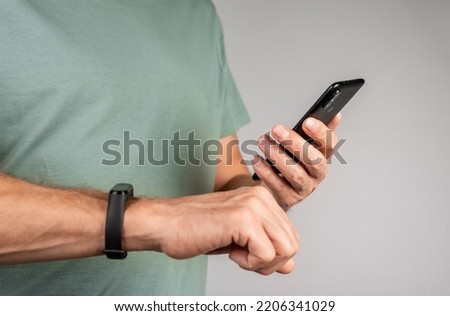 Using mobile phone app and smart fitness bracelet for measuring sport activity. Royalty-Free Stock Photo #2206341029