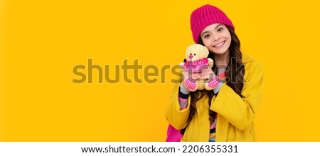 Winter school. Funny school girl with toy. Happy childhood and kids education. Banner of child girl with toy, studio portrait, header with copy space.