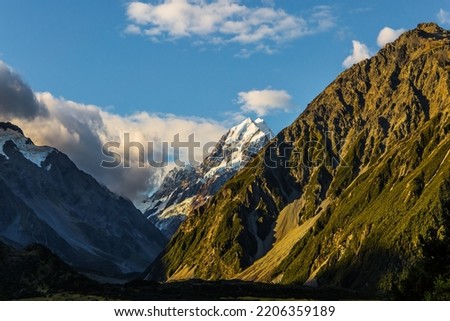 Evening twilight in the valleys. The highest mountain in New Zealand is Aoraki, or Mount Cook. The top of the mountain is covered with eternal snows. The concept of active, walking and photo tourism Royalty-Free Stock Photo #2206359189