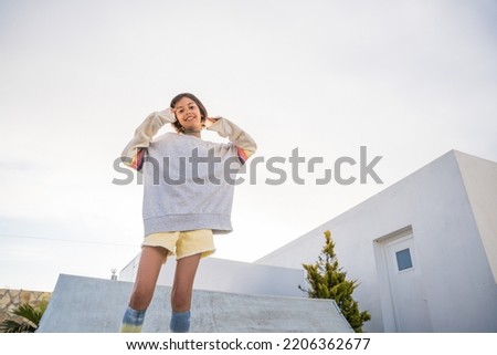 Overjoyed teen girl in street style clothes looking at the camera and smiling toothy
