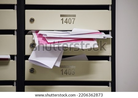 An overflowing mailbox in the lobby of an apartment building. Mailboxes full of letters with apartment numbers Royalty-Free Stock Photo #2206362873