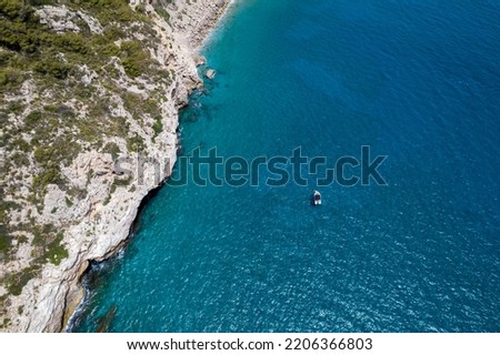 drone view between of a mediterranean sea and a coastline with a boat in the sea