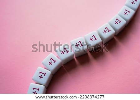 Chain of blocks with plus one to the sum. Addendum. Gradual growth. Attract more followers. Heading for success. Consistency and regularity. A series. Accumulation, arithmetic progression. Royalty-Free Stock Photo #2206374277