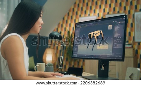 Asian woman working on pc in 3D modeling program remotely from home office and creating 3D prototype of modern robot