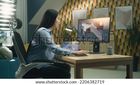 Female asian 3D designer creating 3D model of electric guitar and making graphic, using software for modeling 3D projects while working on pc and tablet at home.