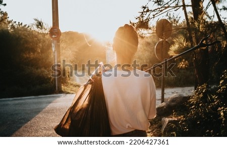 Back shot image woman holding a trash bag and a garbage collector while cleaning the forest. Royalty-Free Stock Photo #2206427361