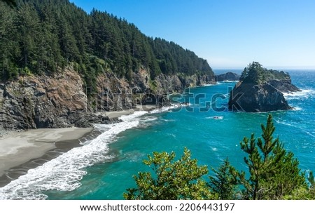 A sunny afternoon image of the beach and rocky cliffs that are south of the Arch Rock in the southern part of the Oregon Coast. Royalty-Free Stock Photo #2206443197