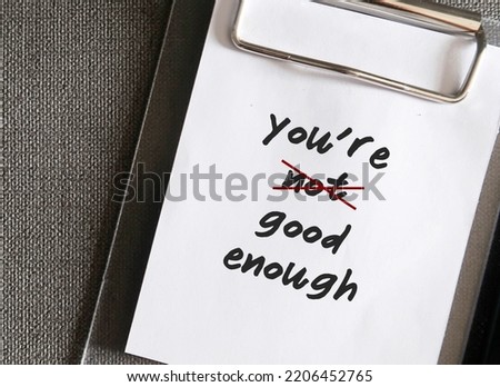 Paper clip with handwritten text YOU'RE NOT GOOD ENOUGH, crossed NOT off - concept of to correct self talk to break negative mindset, overcome low self-esteem and build self-acceptance Royalty-Free Stock Photo #2206452765