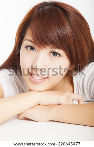 closeup of smiling young woman lying prone over white background