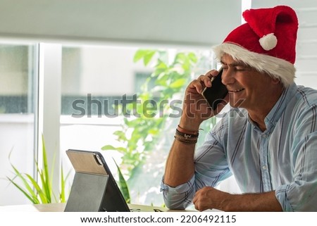 man with santa hat and mobile phone at christmas