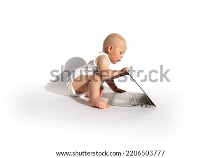 Cute baby playing with laptop computer. Early childhood education concept. Negative impacts of electronic devices on children. Protection, interlock, kids mode, parental control, child lock apps.